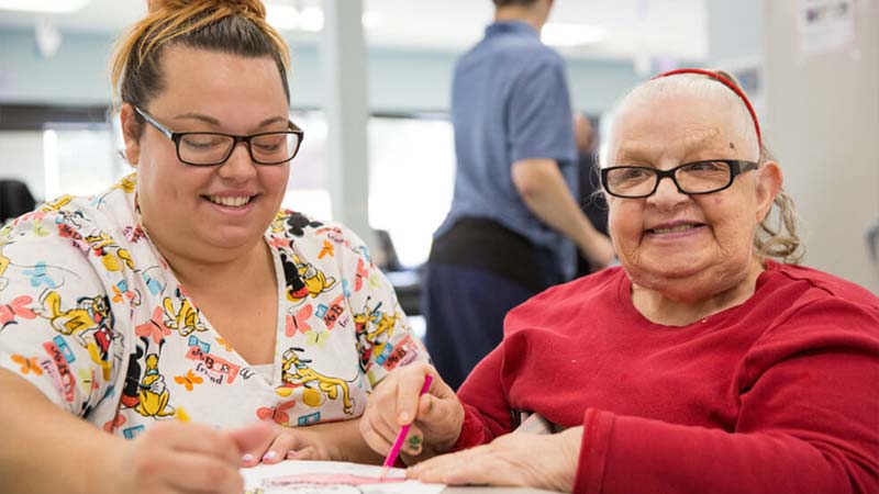 Two women doing activities at table